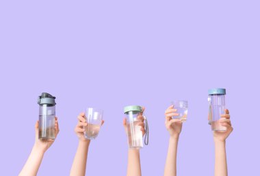 Şişeli kadın elleri ve arkaplanda bir bardak su.