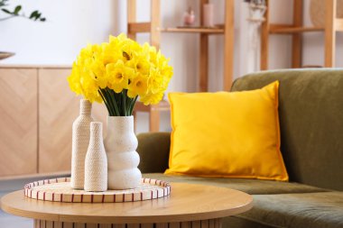 Rahat kanepesi, sehpası ve narsisli çiçekleri olan şık bir oturma odası.