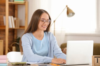 Female tutor with laptop giving online lesson at home