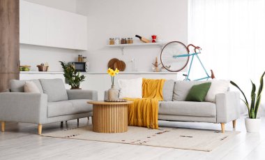 Gri koltukları, kahve masası ve bisikleti olan şık bir oturma odası.