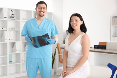 Erkek doktor, hastanede akciğer ve hastanın röntgen görüntülerini inceliyor.