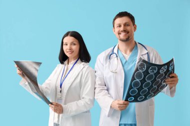 Mavi arkaplanda x-ışını görüntüleri olan doktorlar