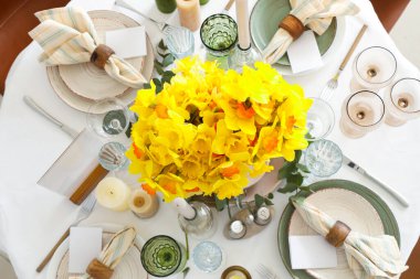 Düğün kutlaması için nergis ve mumlarla dolu güzel bir masa.