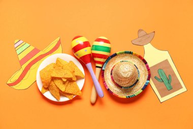 Meksika marakası, sombrero, nachos ve turuncu arka planda dekor. Cinco de Mayo