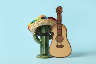 Kaktüs, sombrero, bıyık ve mavi arka planda kağıt ukulele. Cinco de Mayo