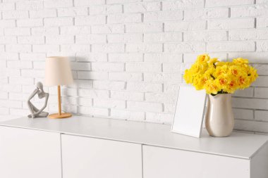 Nergis çiçekleri göğüs çekmecesinde, oturma odasında süsleme ile birlikte.