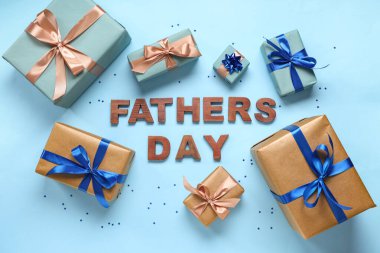 Hediye kutuları ve mesaj Babalar Günü mavi arka planda ahşap harflerle yapılır. Üst görünüm