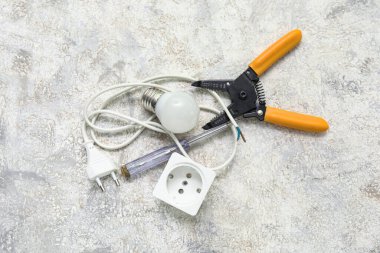 Beyaz grunge arka planda elektrikçi araçları, soket ve ampul