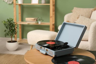 Odadaki sehpanın üzerinde diskleri olan bir pikap.