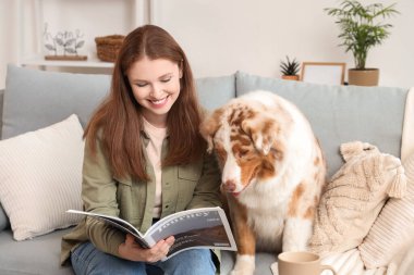 Evde şirin bir Avustralya çoban köpeği dergisi olan genç bir kadın var.
