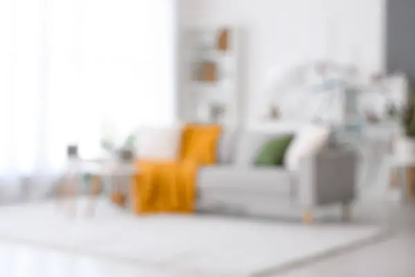 stock image Interior of light living room with comfortable sofa, coffee table and bicycle, blurred view