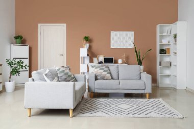 Koltukları ve raf üniteleri olan şık bir oturma odası.