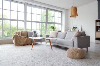 Masasında modern aletler ve kanepelerle aydınlık oturma odasının içinde.