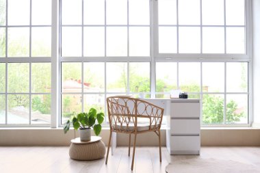 Odada büyük pencerenin yanında fotoğraf makinesi olan masa