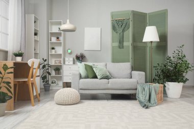 Yeşil perdeli, kanepeli ve bitkilerli oturma odasının içinde.