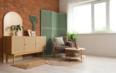 Masa, çekmeceler, koltuk ve katlanır ekran şık bir oturma odası.