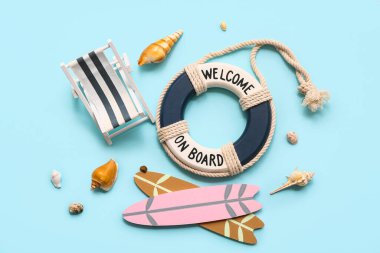 Güverte sandalyesi, sörf tahtası, can simidi yüzüğü ve mavi arka planda deniz kabukları. Yaz konsepti