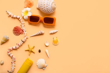 Bej arka planda güneş gözlüğü ve deniz kabukları. Yaz konsepti