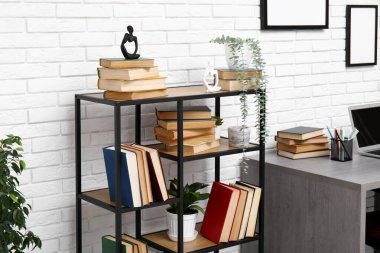 Beyaz tuğla duvarın yanında çalışma yeri ve kitaplığı olan modern oturma odası.