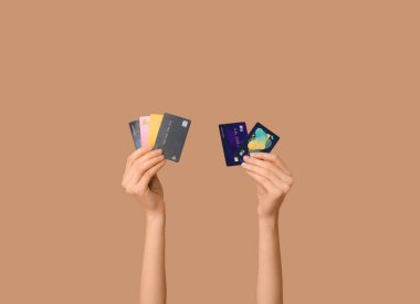 Female hands with credit cards on brown background