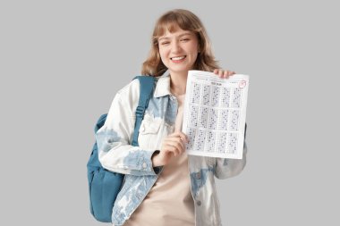 Sınav sonuçları açık arka planda olan mutlu kız öğrenci.