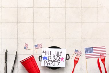 Üzerinde 4 Temmuz barbekü partisi, yemek takımı ve arka planda Amerikan bayrakları olan kart.