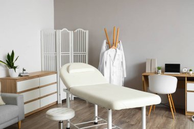 Kanepe, giysi askılığı ve doktorların çalışma yeri olan bir hastane.