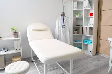 Kanepe, giysi askılığı ve raf üniteleri olan bir hastane.