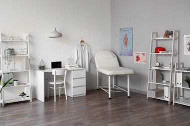 Kanepe, raf üniteleri ve doktorların iş yeri olan hafif tıp bürosu.