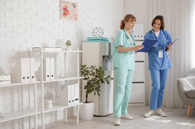 Klinikte panosu olan kadın stajyerler.