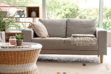 Interior of living room with cozy grey sofa and coffee table