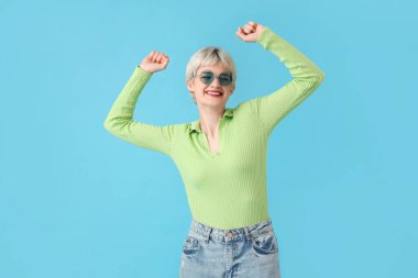 Portrait of beautiful young  woman with sunglasses on blue background