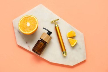 Renkli serumlu yüz masajı silindiri ve turuncu parçalar.
