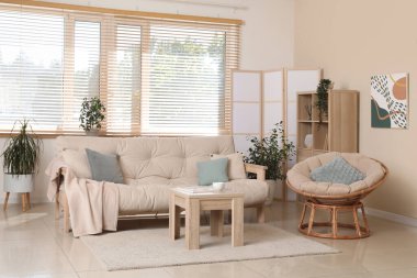 Rahat kanepesi, koltuğu, sehpası ve katlanır ekranı olan şık bir oturma odası.