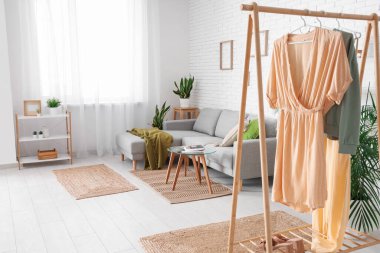 Rahat kanepesi, çiçekleri, sehpası ve raf ünitesi olan bir oturma odası.