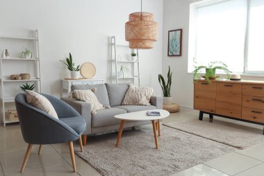 Gri kanepesi, sehpası ve koltuğu olan modern oturma odası.