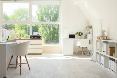 Masaları, raf birimleri ve yazıcısı olan ışık ofisinin içi