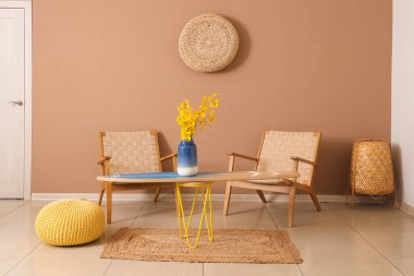 Sörf tahtası, rahat koltuklar ve salonda çiçekli vazo.