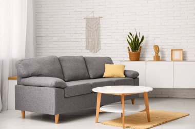 Oturma odasının iç tarafında yastıklı ve sehpalı rahat bir kanepe.