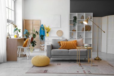 Oturma odasının içinde kanepe, işyeri ve sörf tahtası var.