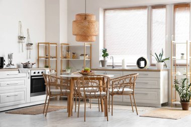 Yemek masası, sandalyeler ve lamba şık bir mutfakta.