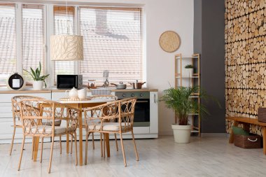 Yemek masası, sandalyeleri, fırını ve lambası olan şık bir mutfak.