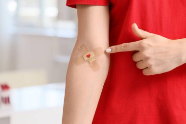 Klinikte uygulamalı yamayı gösteren kadın kan bağışçısı, yakın plan.