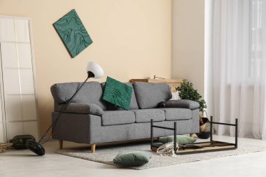 Depremden sonra kanepe ile yıkılmış oturma odasının içi.