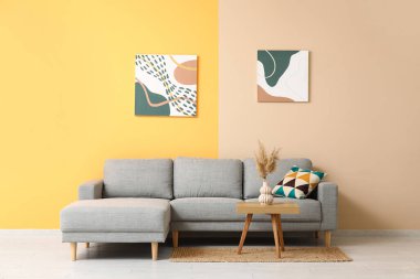 İçinde rahat bir kanepe, resimler, otlar ve kahve masası olan güzel bir oturma odası.