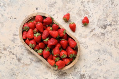 Ahşap tepsi ve arkaplanda taze çilek.