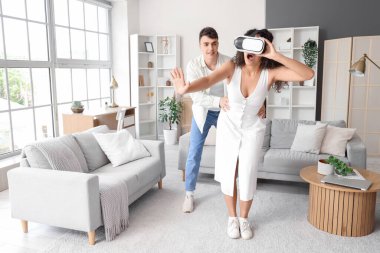 Sevgilisi evde gözlük takan genç bir adam.