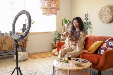 Genç Afro-Amerikalı cadı Tibet şarkı kasesi ile evinde video kaydediyor.