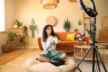 Evde keçi kafatası kayıt videosu olan genç Afro-Amerikan cadı.