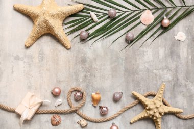 Deniz yıldızı, deniz kabuğu, ip ve gri grunge arka planda Noel dekoru olan palmiye dalı. Üst görünüm